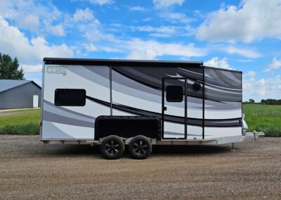 Exterior curbside view of the CORE RV 8022 with black and grey swooped graphics and awning