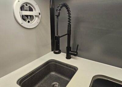 Interior view of the CORE 6515 Trailhead small sink, faucet and fan