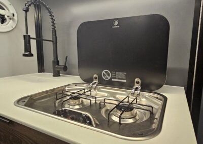 Interior view of the CORE 6515 Trailhead 2 burner cooktop and small sink